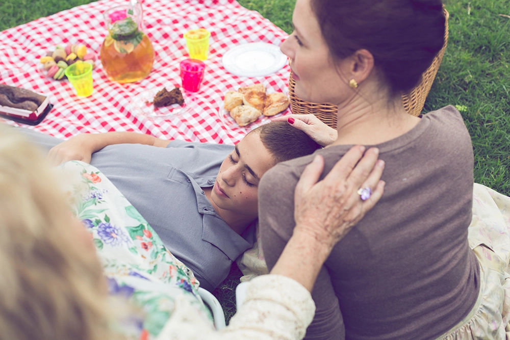 משפחה עושה פיקניק בחצר עם סבתא