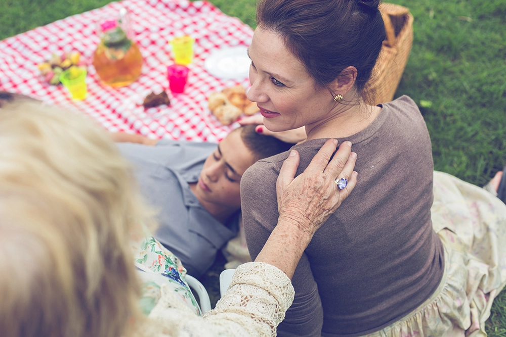 משפחה עושה פיקניק בחצר עם סבתא